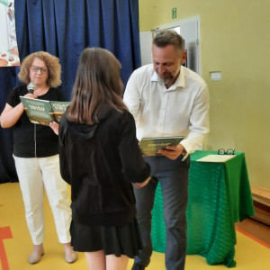 Pan dyrektor wręcza nagrodę uczennicy.