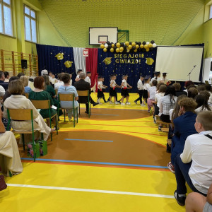 Sala gimnastyczna w szkole, przedszkolaki tańczą poloneza