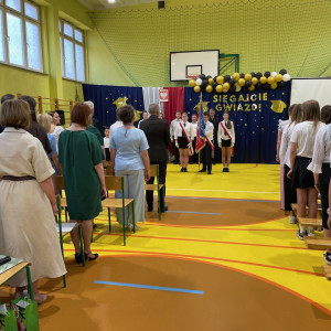 Sala gimnastyczna w szkole, poczet prezentuje sztandar szkoły