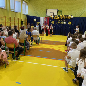Sala gimnastyczna w szkole, wyczytywanie osoby do odebrania nagrody